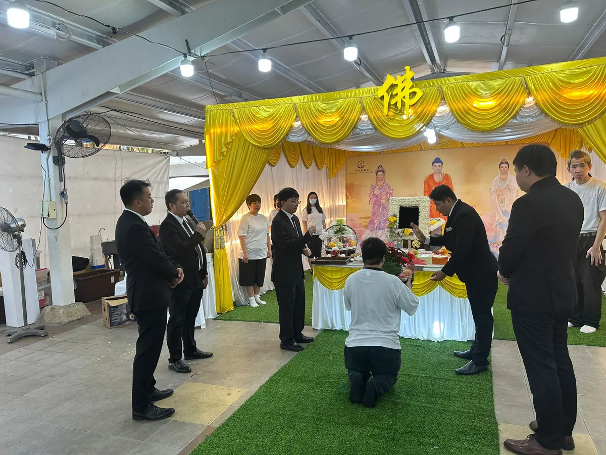 家属跪拜参与佛教丧礼祈祷