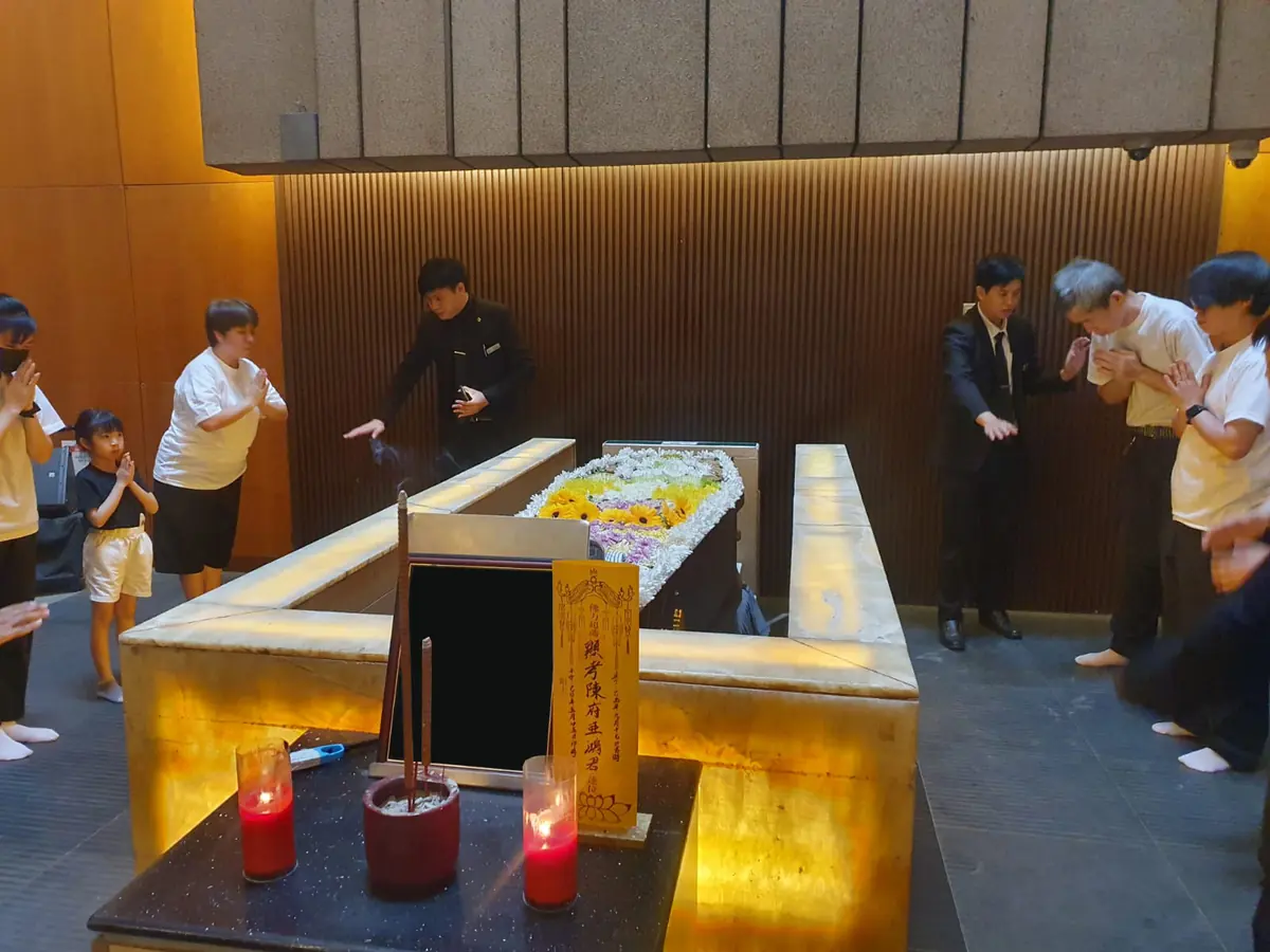 家属围绕棺木进行最后佛教祈祷