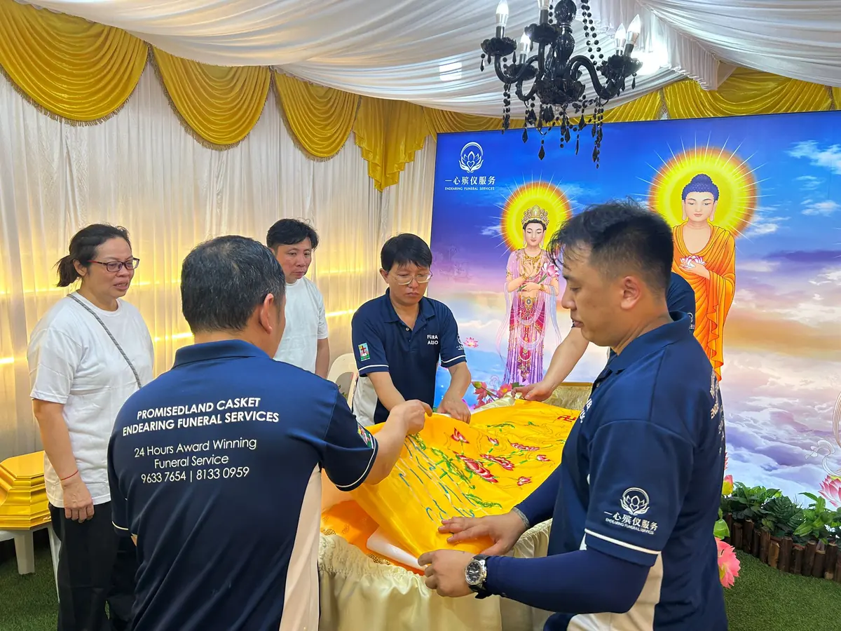 家属在最后仪式中覆盖佛教祝福布
