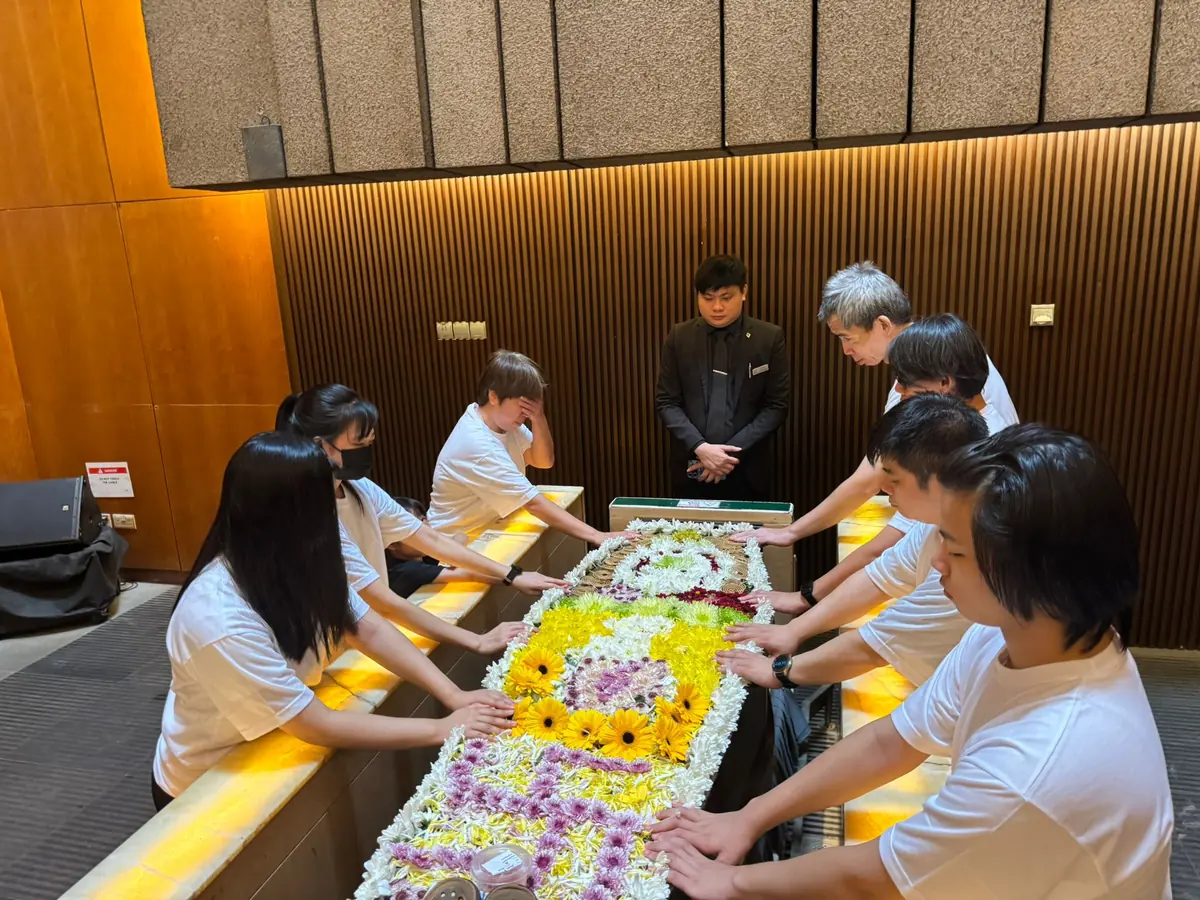 家属在棺木前进行最后佛教祈祷